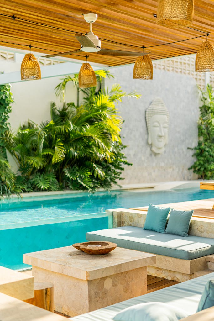 Elegant outdoor pool area featuring tropical plants and modern seating for relaxation.